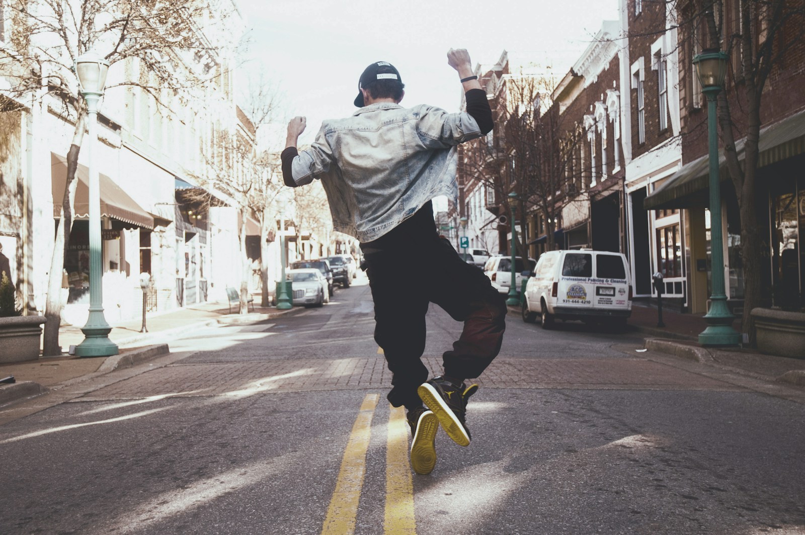 man jumping on the middle of the street during daytime - refinancing, home, happy.