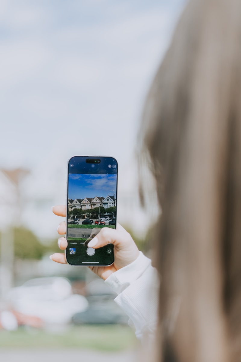 Taking a picture of local houses to buy with a smartphone to send to a mortgage broker for a home loan.